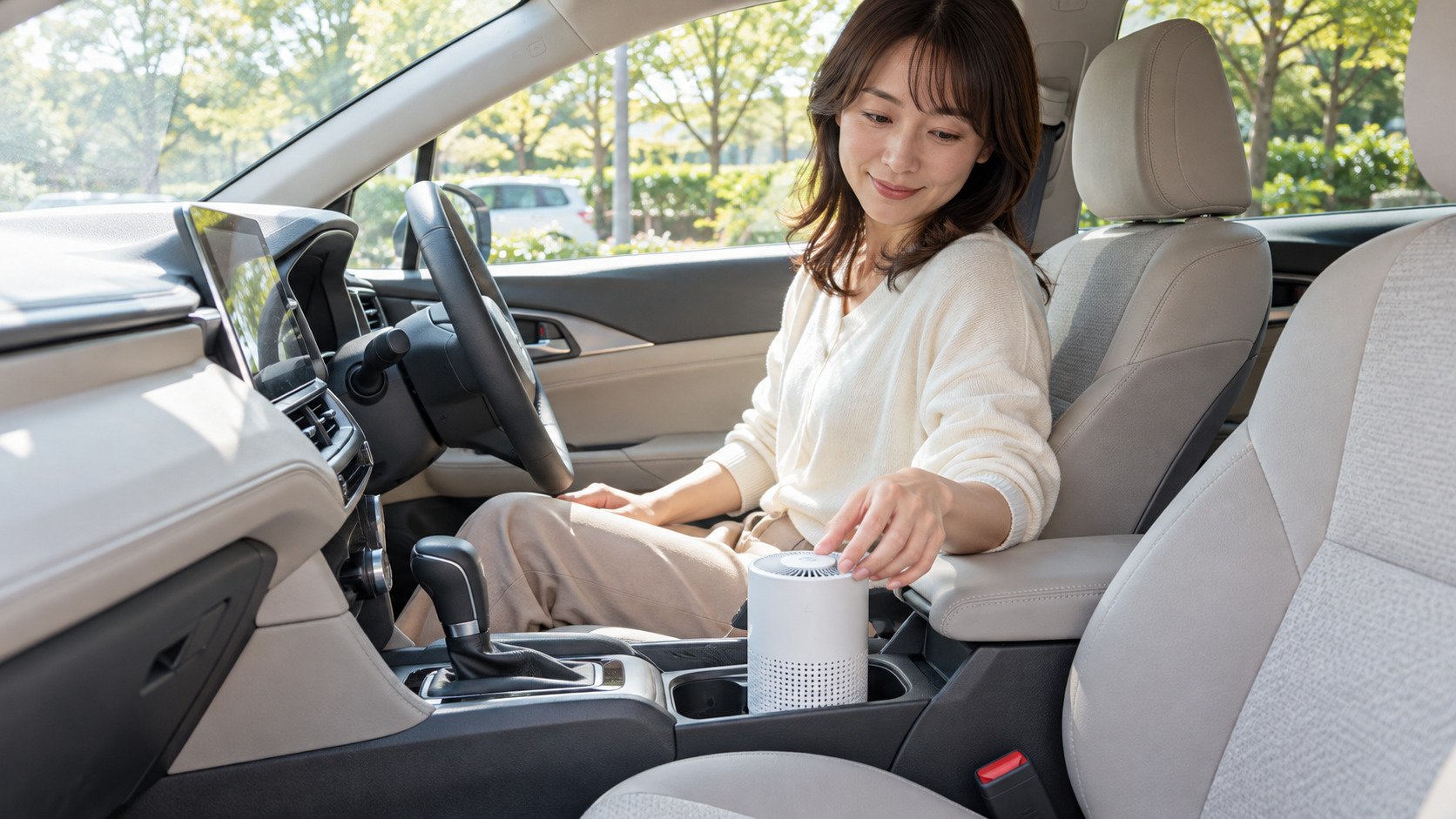 車内の小型空気清浄機を確認する女性